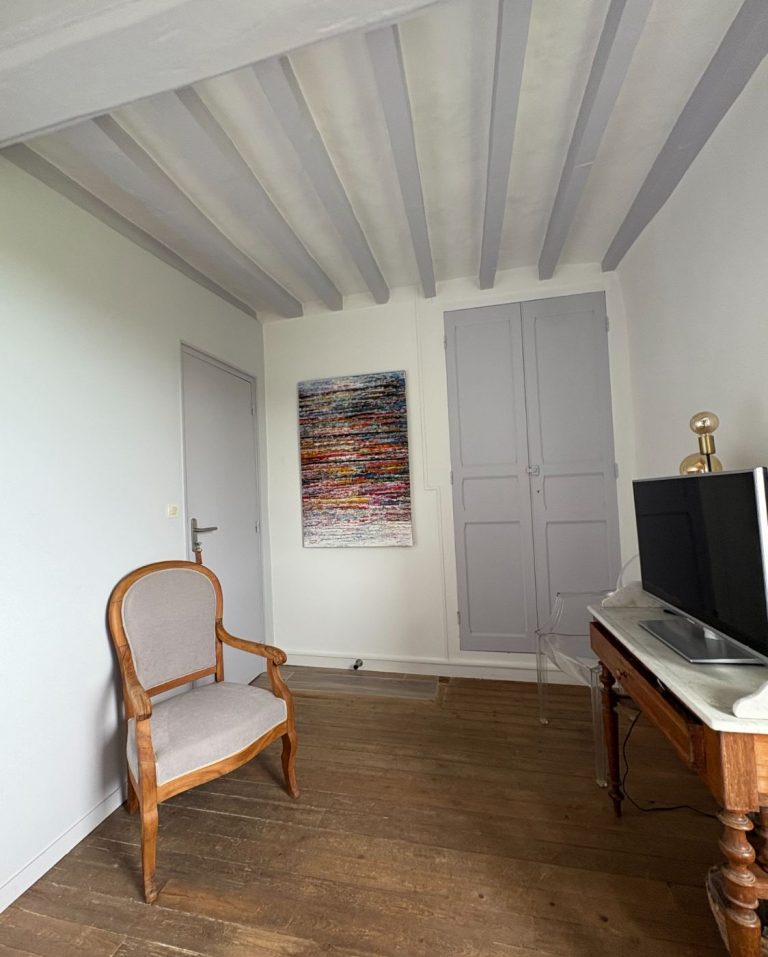 Fauteuil, bureau ancien, télévision et fenêtre de toit de la chambre La Chambre Mauve