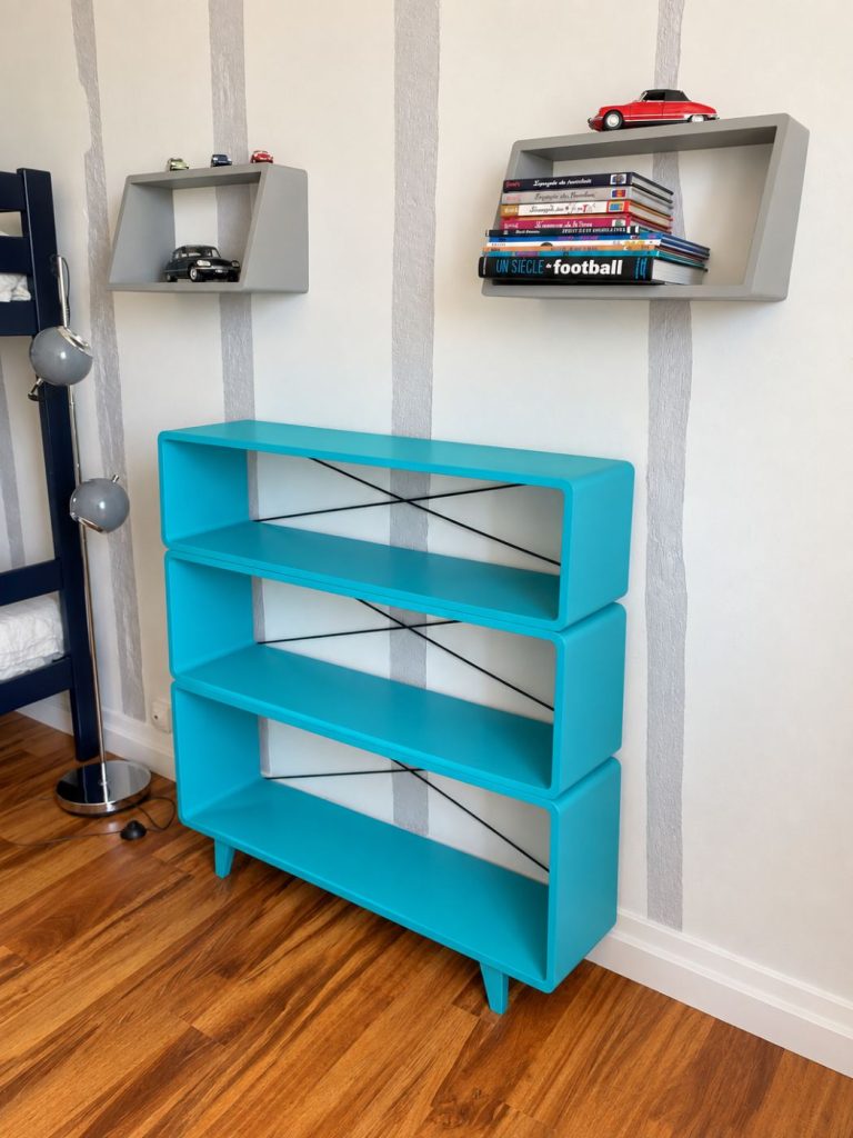 Étagères turquoise et livres pour enfants dans la chambre Le Perchoir