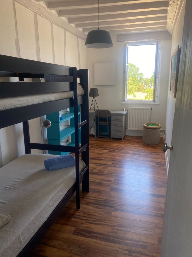 Lits superposés bleu nuit contre le mur à colombages de la chambre Le Perchoir